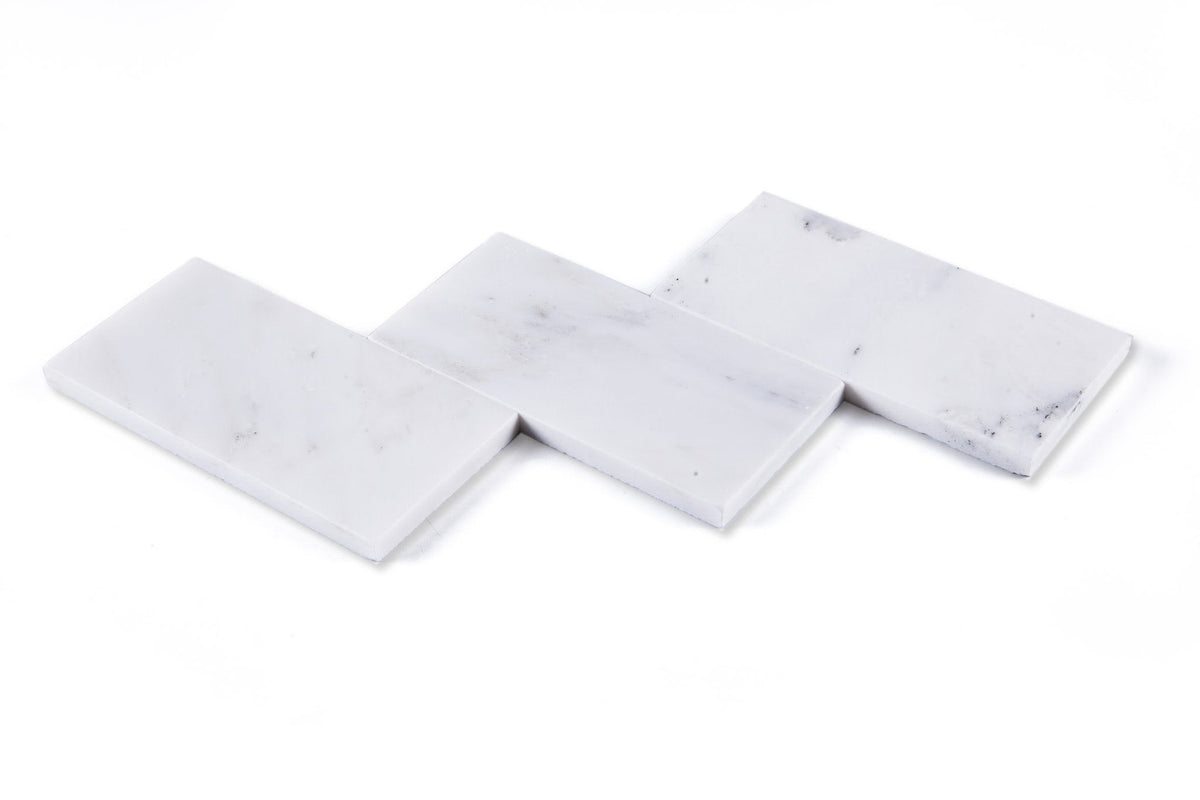 Closeup of three white marble 3x6 subway tiles