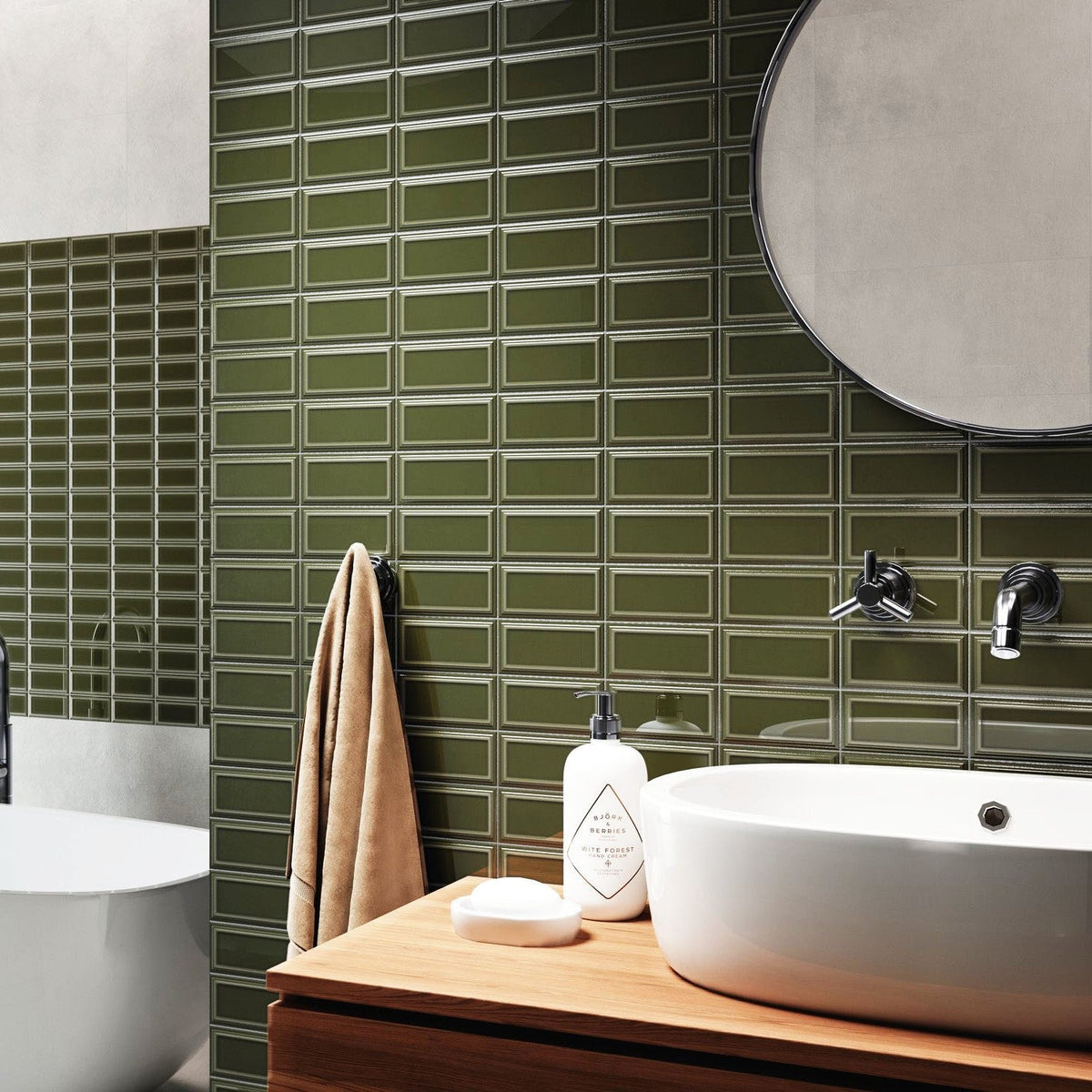 Bathroom vanity with white vessel sink, round mirror, and green ceramic bevel subway tile backsplash.