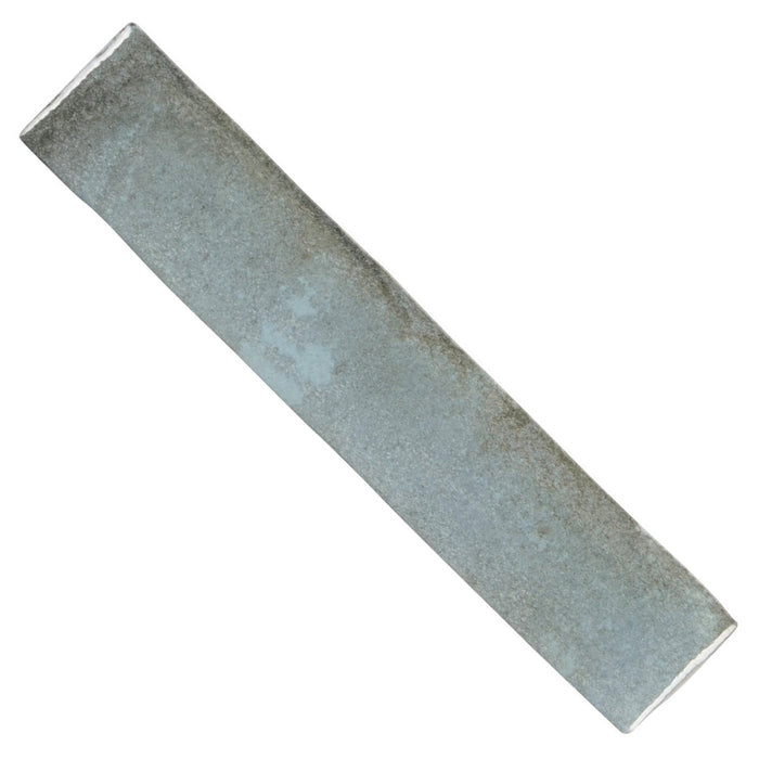 Closeup of a single ceramic subway tile with pale aquamarine blue color and gray accents