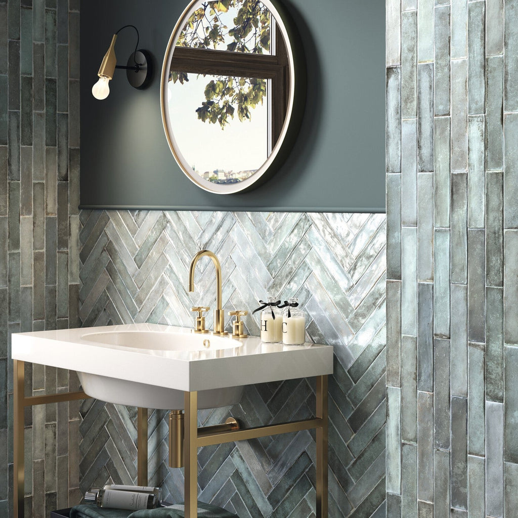 Bathroom vanity and tiled walls featuring pale grayish-blue ceramic subway tile in herringbone and vertical staggered layouts.
