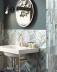 Bathroom vanity and tiled walls featuring pale grayish-blue ceramic subway tile in herringbone and vertical staggered layouts.
