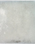 Closeup of a single bluish-gray glossy ceramic 4x4 square tile for walls.