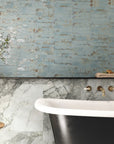 Bathroom with black and white freestanding tub, stone tub surround, and distressed aqua blue ceramic picket tile accent wall