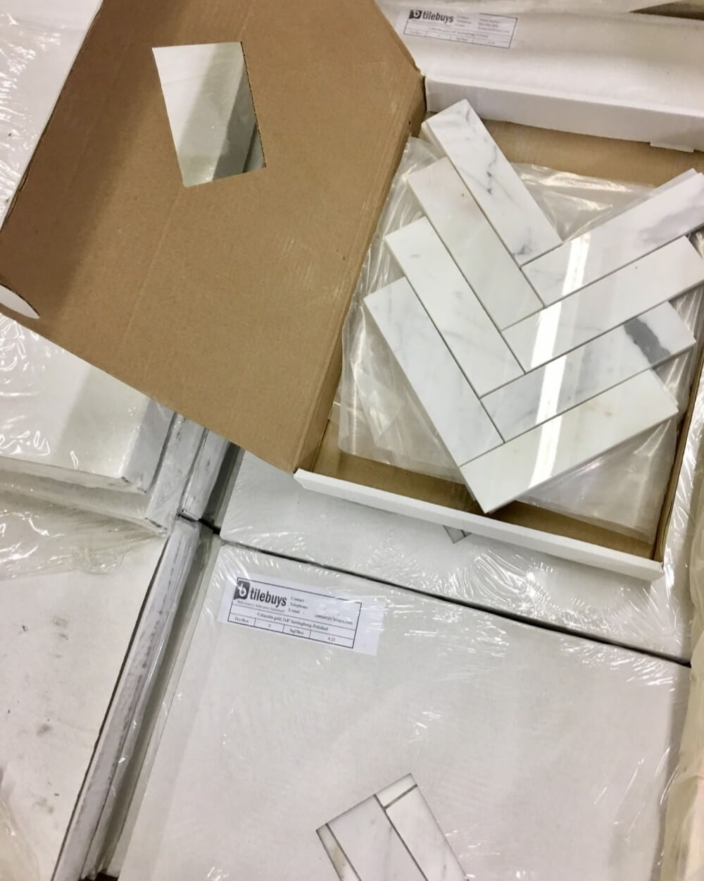 Boxes of Calacatta Gold Marble Herringbone Tiles